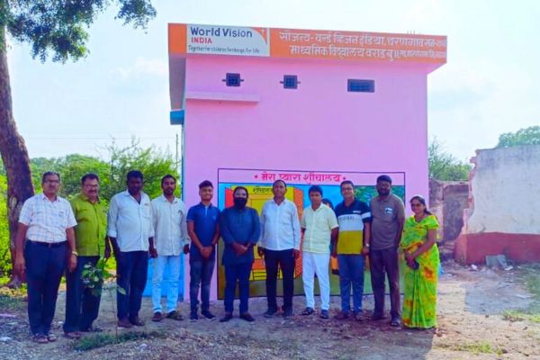 Three girls are standing and smiling in a photo